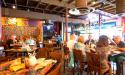 Patrons dine on colorful tabletops, surrounded by colorful walls.